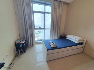 a bedroom with a bed and a large window at Stylish 2 BR Apartment in Ajman Residences Tower 4 in Ajman 