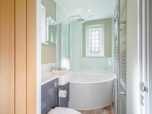 a bathroom with a tub and a sink and a toilet at 3 Bed in Bideford oc-78796 in Northam +29 photos