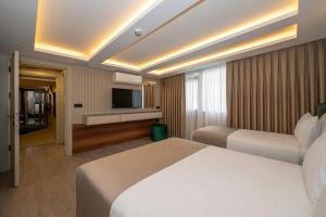a hotel room with two beds and a television at Karaköy Prive Suites in Istanbul