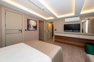 a bedroom with a bed and a flat screen tv at Karaköy Prive Suites in Istanbul