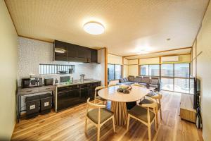 a kitchen and living room with a table and chairs at 夢思苑 別府 in Beppu