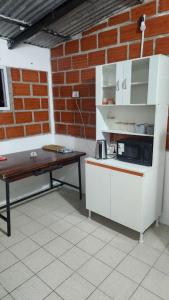 a kitchen with a counter and a table and a brick wall at Norte Hogar in Salta