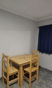 a wooden table and chairs in a room at Norte Hogar in Salta