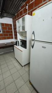 a kitchen with a white refrigerator and a brick wall at Norte Hogar in Salta