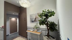 a hallway with a potted tree and a picture of wolves at Villa Saint Enogat in Aix-les-Bains +131 photos
