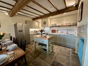 a large kitchen with a table and a refrigerator at Moorlands Farm Holidays in Keighley