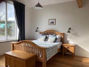 a bedroom with a wooden bed and a window at Moorlands Farm Holidays in Keighley