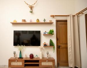 a living room with a tv on a wall at Inayat-Pet friendly boutique homestay in Dehradun