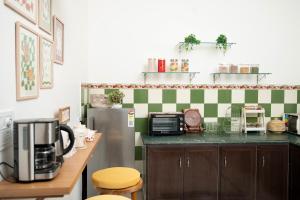 a kitchen with a refrigerator and a counter with a microwave at Inayat-Pet friendly boutique homestay in Dehradun