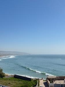 a view of a beach with people in the water at Vitamin taliouine appartement in Taghazout +16 photos
