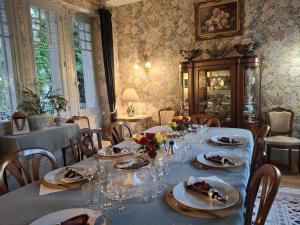 a dining room with a table with plates and wine glasses at Château Picol entre Futuroscope et Châteaux de la Loire in Lencloître