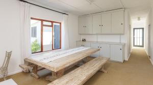 a kitchen with a large wooden table and benches at 206 On Main in Agulhas