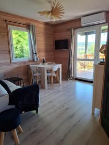 a living room with a table and a dining room at Chalet familial avec piscine chauffée, jeux et brasero- Morvan in Voudenay-lʼEglise