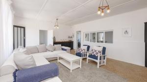 a living room with a white couch and chairs at 206 On Main in Agulhas