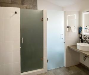 a bathroom with a sink and a glass shower door at Hotel Kéri Inn in Guadalajara