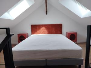 a bed in a room with two red speakers at Le petit marais in Le Mans