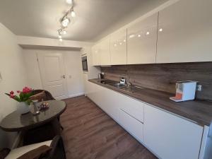 a kitchen with white cabinets and a table and a sink at Jaegersruh Vicht in Fleuth