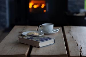 a book and a cup of coffee on a wooden table at Jog Lodge 10 By Together Travel - 3 Bed in John O Groats