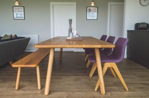 a wooden table with purple chairs in a room at Jog Lodge 10 By Together Travel - 3 Bed in John O Groats +11 photos