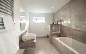 a bathroom with a bath tub and a sink at Jog Lodge 10 By Together Travel - 3 Bed in John O Groats