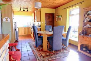 a dining room with a table and chairs and a kitchen at 4 Bedroom House By Travel Lets Holiday Homes Downings With Atlantic View in Downings