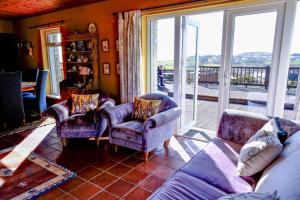a living room with a couch and chairs and a large window at 4 Bedroom House By Travel Lets Holiday Homes Downings With Atlantic View in Downings