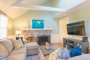 a living room with a couch and a fireplace at Spacious Stone Fire Pit Game Room in Barnstable