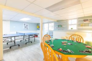 a dining room with a ping pong table and chairs at Spacious Stone Fire Pit Game Room in Barnstable