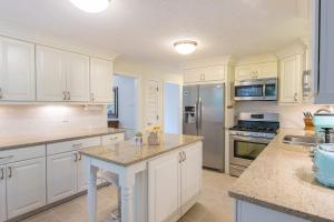 a kitchen with white cabinets and a counter top at Spacious Stone Fire Pit Game Room in Barnstable +31 photos