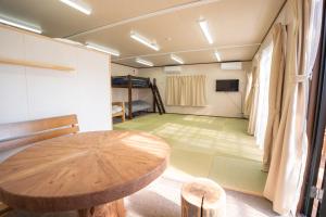 a room with a wooden table and a green floor at 皓雲庵plus in Miyakonojō