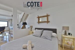 a white bedroom with a bed and a staircase at A La Vaquera - Gîte équestre in Châteauneuf-lès-Martigues