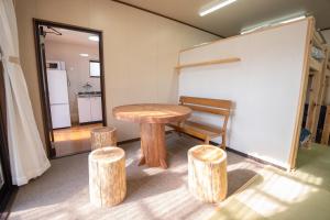 a table and two stools in a room at 皓雲庵plus in Miyakonojō