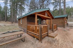 a log cabin with a bench in front of it at Raven Rock Getaway- Firepit Nights Getaway in Rapid City