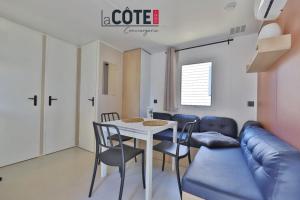 a living room with a table and chairs and a couch at Lou Soleil - Bungalow - 6 couchages in Carry-le-Rouet