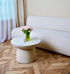 a vase of flowers on a table next to a couch at Bohemian in Šamorín +14 photos