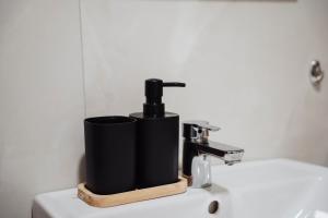 a black soap dispenser sitting on top of a sink at Sky View - Apartment & GARAGE, Banja Luka in Banja Luka +32 photos