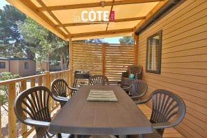 a table and chairs on a deck with a coffee sign at Lou Soleil - Bungalow - 6 couchages in Carry-le-Rouet +15 photos