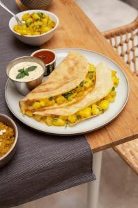 a plate with a sandwich with corn salsa and dip at The Vedam Hotels - Ram Mandir Ayodhya A unit of RL Group of Hotels Ayodhya in Ayodhya +15 photos