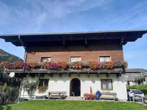a house with a balcony with flowers on it at Bamerhof in Mittersill