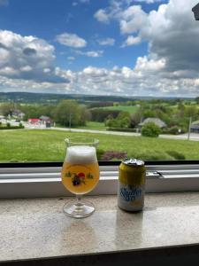 a glass of beer and a can on a window sill at L'Horizon Studios & Apparts in Malmedy