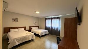 a hotel room with two beds and a television at Hotel Recife in Ciudad del Este +11 photos