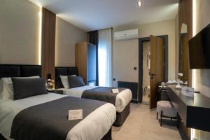 a hotel room with two beds and a desk at Kucuk Velic Hotel in Gaziantep