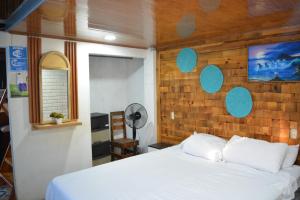 a bedroom with a white bed and a wooden wall at MARIBAO in Playas +102 photos
