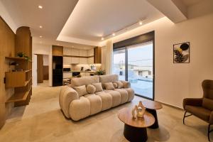 a living room with a couch and a kitchen at POLYTELIA - Luxury Living in Elaía