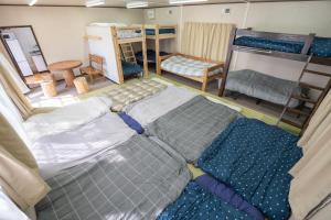 a room with a group of beds and bunk beds at 皓雲庵plus in Miyakonojō