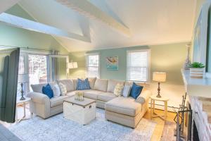 a living room with a couch and blue pillows at Spacious Stone Fire Pit Game Room in Barnstable