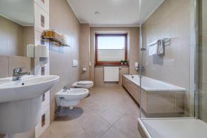 a bathroom with a sink and a toilet and a bath tub at Hotel Aviator - kompleks Silesia Ring in Kamień Śląski +46 photos