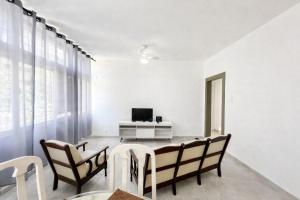 a dining room with a table and chairs and a television at Residencial Dois58 in Niterói