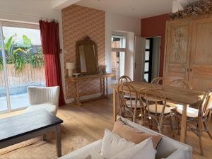 a living room with a wooden table and chairs at La maison cocooning in Narbonne