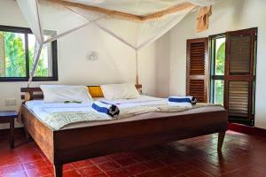 a bedroom with a large bed in a room at Kusini Beach Cottages in Diani Beach +47 photos